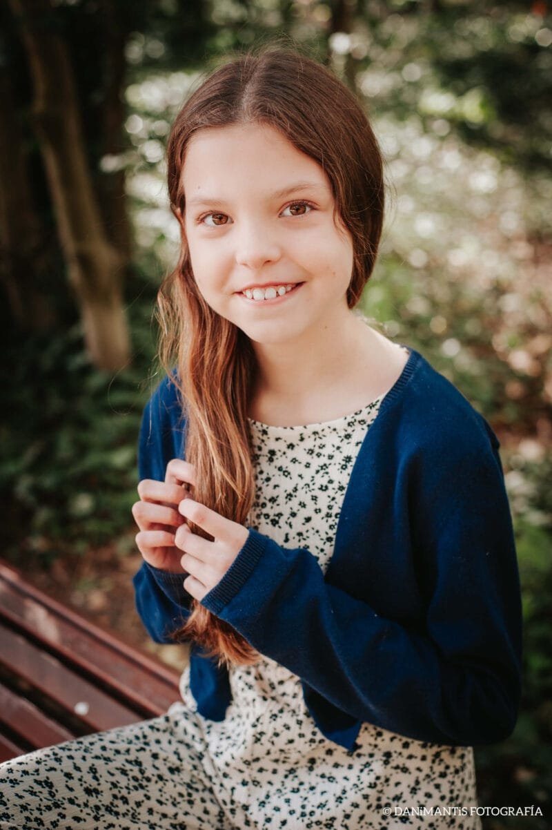 Retrato de Isabel, autora de Carolina Purpurina, sonriente en el jardín.