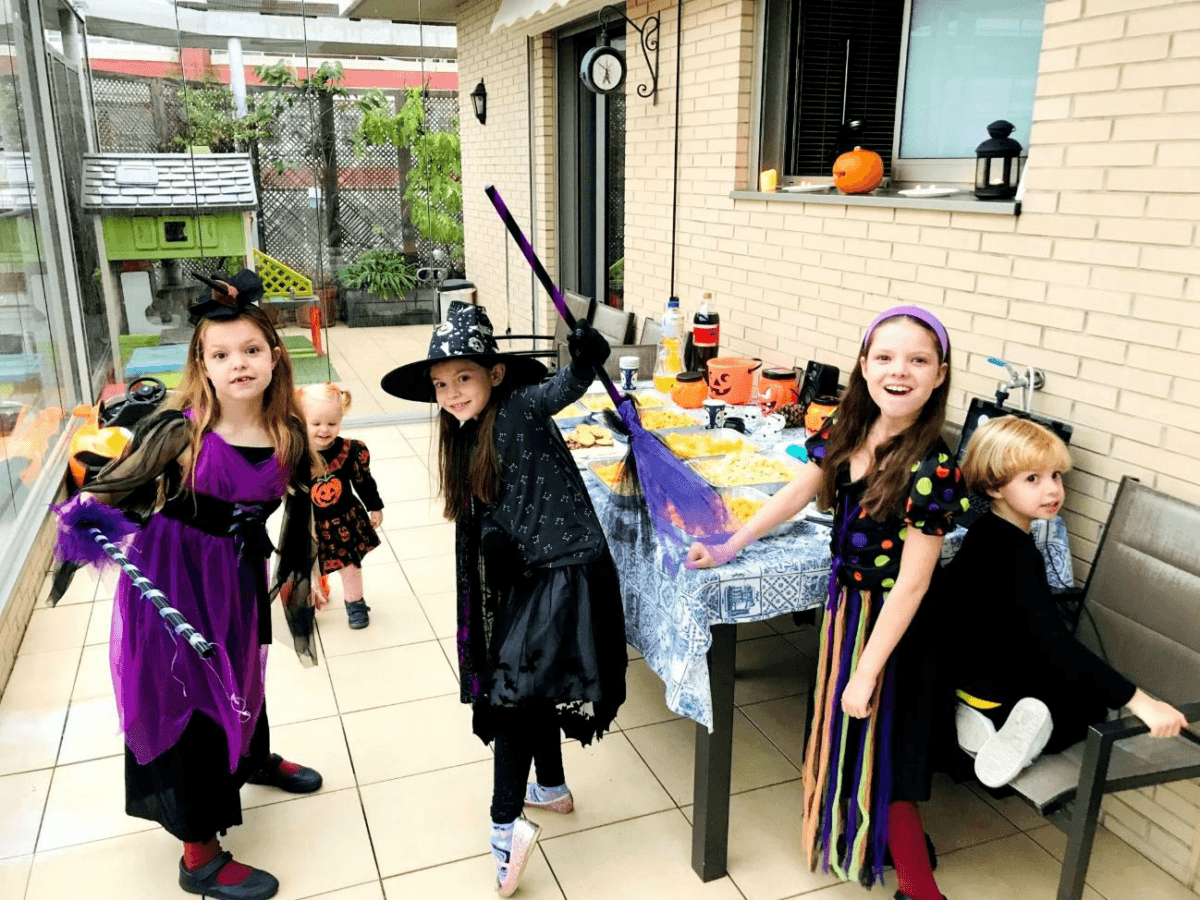 Fiesta de cumpleaños de Carolina Purpurina: los niños disfrazados de brujas junto a la mesa decorada con calabazas.